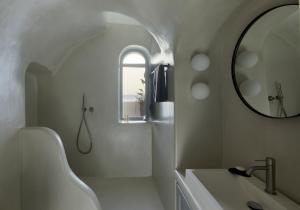a white bathroom with a sink and a mirror at Inspire Santorini Luxury Villas in Fira