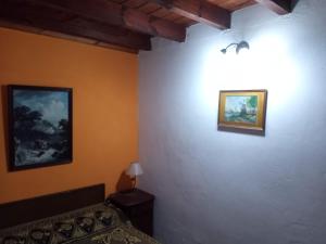 1 dormitorio con 1 cama y 2 cuadros en la pared en Amplia casa con estacionamiento cerca del mar en Mar de Ajó