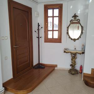 Zimmer mit einer Tür, einem Tisch und einem Spiegel in der Unterkunft Grevena country House 