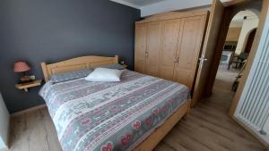 a bedroom with a bed and a wooden cabinet at Casa Rita in Tesero