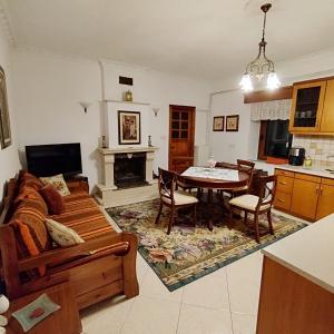 ein Wohnzimmer mit einem Sofa und einem Tisch in der Unterkunft Grevena country House 