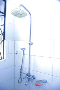 a shower with a shower head in a bathroom at Karibu Namugongo in Kampala