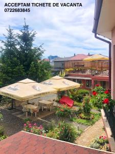 an outdoor patio with umbrellas and tables and flowers at Casa Constantin si Elena ( Adults only ) in Eforie Nord