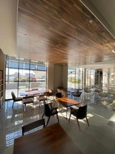 a dining room with tables and chairs and windows at ZEGEN HOTELS LagosdeMoreno in Lagos de Moreno