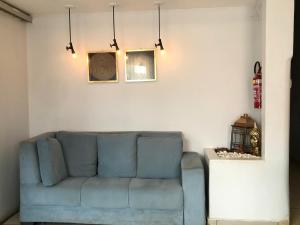 a living room with a blue couch against a white wall at Ágape Hotel in Rio Verde