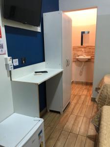 a kitchen with a white desk and a refrigerator at Ágape Hotel in Rio Verde