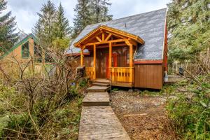 a wooden cabin with a porch and a pathway leading to it at Snowbird Chalet #8 in Girdwood