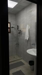 a bathroom with a shower and a sink at Alhara Lodge استراحة الحارة in Hatta