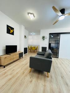 Industrial -Apartamentos Birdie- في البسيط: غرفة معيشة مع أريكة وتلفزيون بشاشة مسطحة