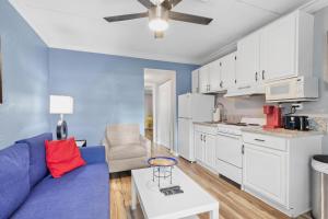 a living room with a blue couch and a kitchen at Sunset Beach Suite 2 in St Pete Beach