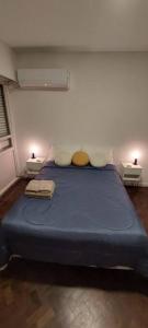 a bedroom with a large blue bed with two tables at A metros del Parana - Centro in Rosario