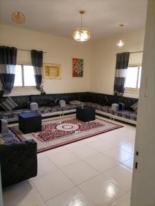 a living room with a couch and a rug at Khair Jewaar Apartments Al Madinah in Al Madinah