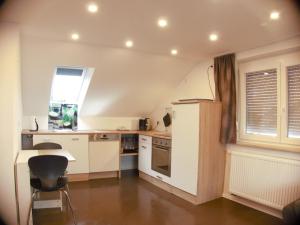 una cocina con armarios blancos y una ventana en Alb-Biosphäre-Ferienwohnung, en Ingstetten