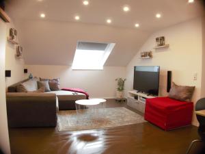 a living room with a couch and a tv at Alb-Biosphäre-Ferienwohnung in Ingstetten