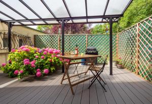 een patio met een tafel en bloemen op een terras bij Horizons Verts Appartement Cerisier in Puivert