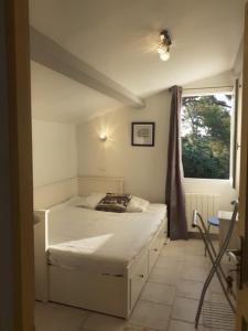 a small bedroom with a bed and a window at Bois Joli in Hyères