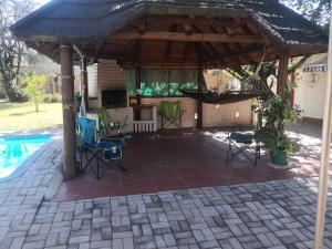 a pavilion with chairs and a grill next to a pool at 15 On Reitz Bela bela in Bela-Bela
