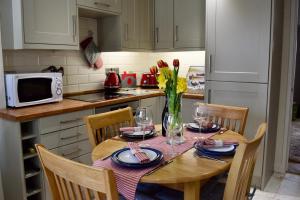 uma cozinha com uma mesa de madeira com um vaso de flores em Chapel View Cottage em Beaminster