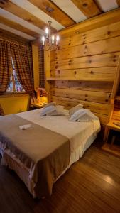 a bedroom with a large bed with a wooden wall at Hotel Giardino Di Pietra in Gramado