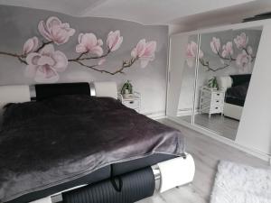 1 dormitorio con 1 cama con flores rosas en la pared en Ubytování Dobešov, en Černovice