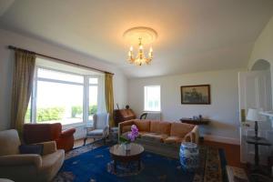 a living room with a couch and a chandelier at Downsview in Kingsdown