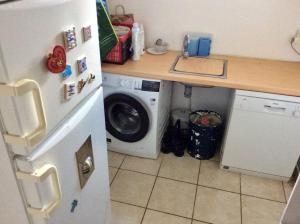 a kitchen with a refrigerator and a washing machine at Les Joncades - Maison de vacances in Saint-Gildas-de-Rhuys