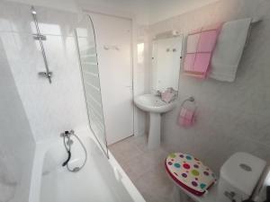 een badkamer met een bad, een wastafel en een toilet bij LE RUN AR MOR 22 in Bas Kerhain