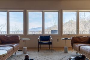a room with a couch and a chair and windows at The Edelweiss Estate in Gatlinburg