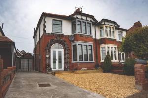a large brick house with a driveway in front of it at Spacious Family Home Minutes from the Beach in Blackpool