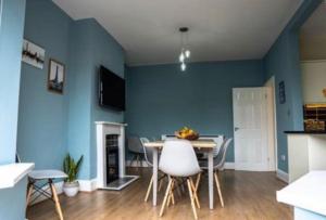 a dining room with blue walls and a table and chairs at Spacious Family Home Minutes from the Beach in Blackpool