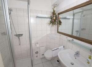 een badkamer met een toilet, een wastafel en een douche bij 7-9, Marienstr, sehr strandnah, Südbalkon mit kleinem Seeblick, 2 Zi in Westerland