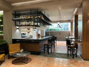 a restaurant with a bar with chairs and tables at St Isidro Suites Corporate Housing SPA & Wellness Center in Mexico City