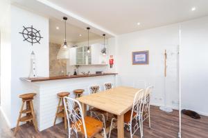 a kitchen and dining room with a wooden table and chairs at BeGuest Tia Benvinda Cascais in Cascais