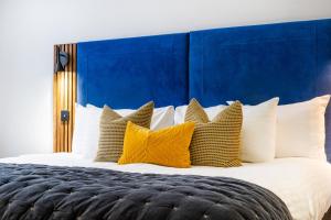 a large bed with yellow and white pillows at The Berkeley Square Hotel Bristol in Bristol