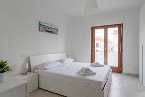 Habitación blanca con cama y ventana en Pantaleone Rapino 56 - YourPlace Abruzzo, en Ortona