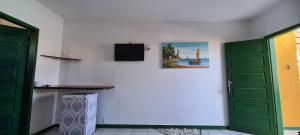 a room with two green doors and a tv on the wall at Pousada Club de Poças in Conde