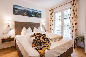 a bedroom with a large white bed with white sheets at Gästehaus Wiesengrund & Apart Sporer in Mayrhofen