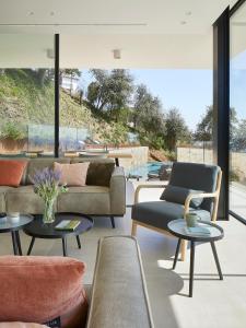 un soggiorno con divani, tavoli e finestre di Casa Pere Costa Brava - by EMERALD STAY a Santa Cristina d'Aro