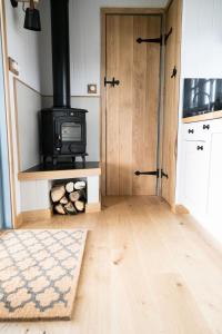 een woonkamer met een houtkachel in een kamer bij Skylark Shepherds Hut in Bath
