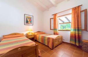a bedroom with two beds and a window at Villa Verd Can Moranta in Alcudia