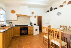 a kitchen with a table and a stove top oven at Villa Verd Can Moranta in Alcudia