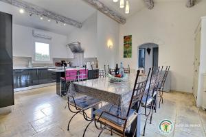 a kitchen and dining room with a table and chairs at Villa L'Opaline 10 pers Piscine privée Chauffée Animaux admis Wifi in Salavas