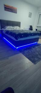 a bed with a blue light on it in a room at Apartman Gavric 2 in Doboj