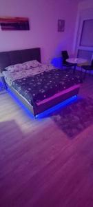 a bed in a room with purple lights at Apartman Gavric 2 in Doboj