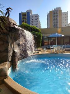 a swimming pool with a water fountain at Flat com parque aquático in Caldas Novas