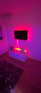 a living room with pink lights and a tv at Apartman Gavric 2 in Doboj