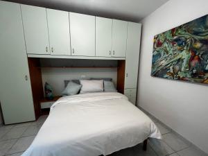 una camera da letto con un letto e un dipinto sul muro di AppArt 21 a Lignano Sabbiadoro