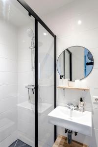 uma casa de banho branca com um lavatório e um espelho em Appartement La Cáscara em Zandvoort