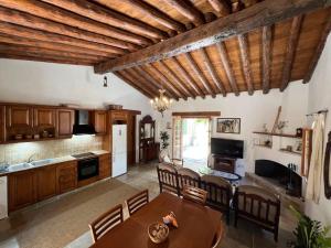 eine Küche und ein Wohnzimmer mit Holzdecken und einem Tisch in der Unterkunft King's house in Lofou