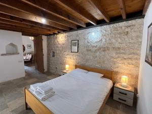 sypialnia z łóżkiem i ceglaną ścianą w obiekcie King's house w mieście Lofu
